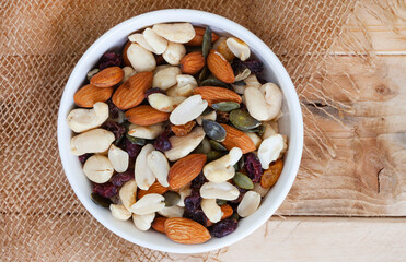 trail mix with nuts and cranberries on rustic grunge background with copy space