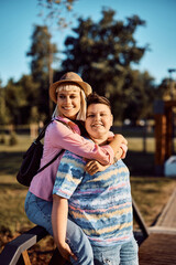 Fototapeta na wymiar Portrait of happy lesbian couple in park looking away.