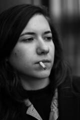 Portrait of a 27 year old white woman, smoking a cigarette