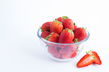 Strawberry in the glass bowl on the white background. Copy space. Closeup.