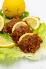 raw meatballs or cigkofte on a white background. Close-up. local name cig kofte