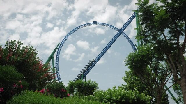 Huge speedy rollercoaster attraction. Rollercoaster train going upward in park