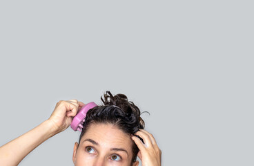 hair growth stimulating, scalp massage.woman using  pink scalp massager shampoo brush with...