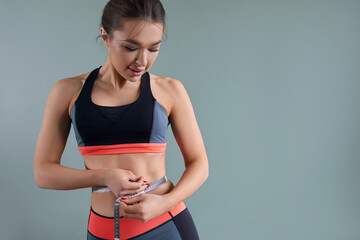 Woman measuring her waistline. Closeup of female with perfect slim body. Weight losing concept.