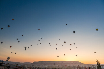 dozens of hot air balloons in the sky in Cappadocia