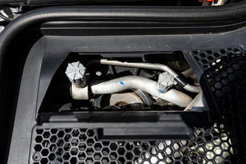 Aluminum air conditioning tubes with a cap, located in the diesel engine compartment.