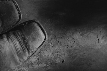 Old western cowboy boots from top view closeup in grunge dark black and white. - obrazy, fototapety, plakaty