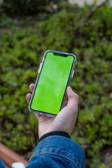 man's hand holding a cell phone with chroma key