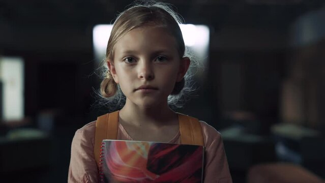 Upset girl holding notebook standing school hall closeup. Schoolgirl frightened 