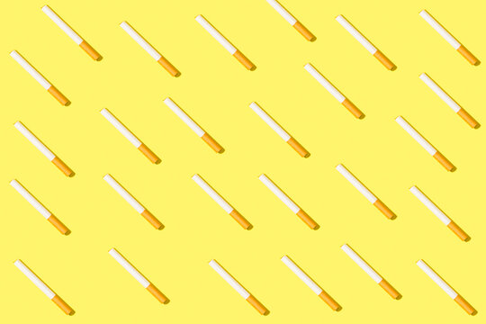 Cigarrillos sobre fondo amarillo liso y brillante. Vista superior.