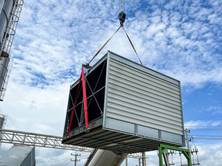 Lift and move the new cooling tower system to install.