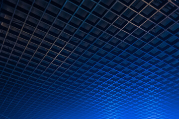 Geometric pattern ceiling grille in the dark with blue neon light abstract interior design, soft focus background