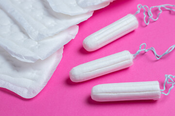 Menstrual tampons and pads on a pink background. Menstruation cycle. Hygiene and protection.