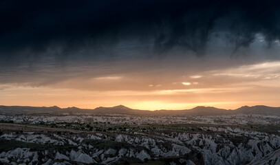 dramatic sunset and rainclouds over the desert of Cappadocia