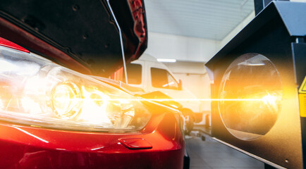Close up checking and adjusting the headlights of a car's lighting system in auto repair service. © andrew_shots