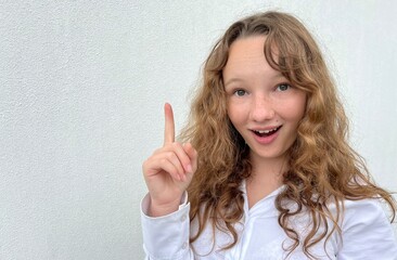 a girl on a white background in a white blouse, fair-haired, shows different cheerful emotions, she...