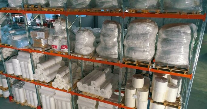 Spunbond on warehouse shelves. Rolls of padding polyester on the shelves of the warehouse. Spunbond in rolls. Non-Woven Fusible Interlining Fabric