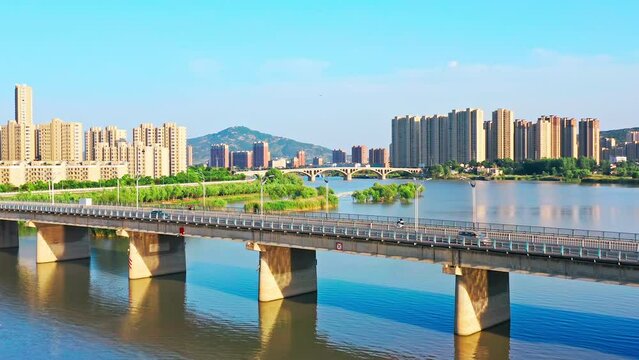 Aerial footage of river and city skyline with bridge in Bengbu, China. 