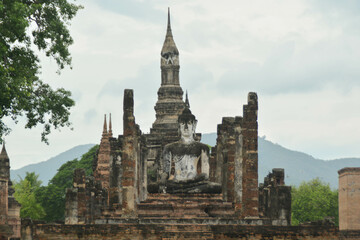 Fototapeta premium Main buddha statue and Phum Khao Bin Pagoda (the sukhothai pagoda unique) in Wat Maha That at the Historical Park in Sukhothai.