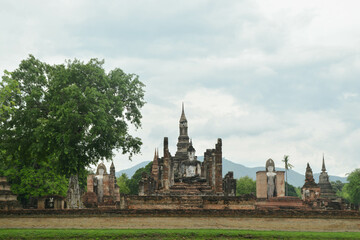 Obraz premium Panning of main buddha statue and Phum Khao Bin Pagoda (the sukhothai pagoda unique) in Wat Maha That at the Historical Park in Sukhothai.