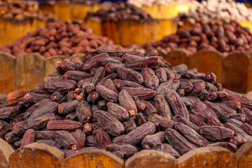 A fresh date-palm and dry date-palm on a wooden trays in the market vintage style.
