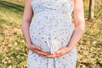 Pregnant woman hugs her belly