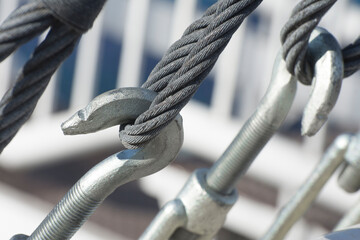 Metal turnbuckles and sling steel in construction site, close up. Fastening of cables with steel...