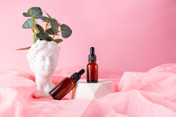 Greek goddess bust and cosmetic glass jars on a pastel pink background. Minimal flat still life....