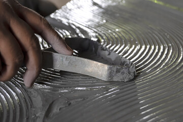 Close up of male sculptor holding tool and making art on clay. Clay master moulding. Clay modelling.