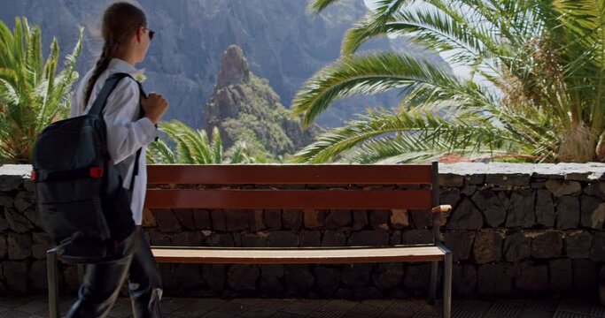 Masca Gorge and village on the island of Tenerife. Girl with backpack walks and sits on a bench and enjoy the view. Slow motion