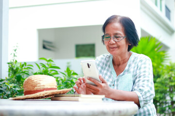 elderly woman living at home holding a smartphone to talk online through the application She smiled...