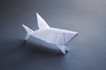 White paper shark origami isolated on a grey background - obrazy, fototapety, plakaty