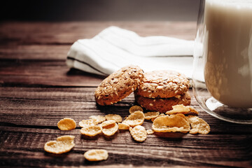 A glass of milk with cookie on a wooden background