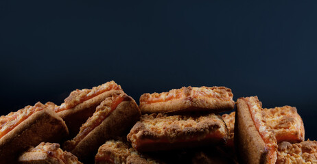 Background of beautiful cookies with orange filling . Square orange cookies .