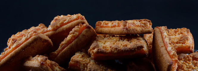 Background of beautiful cookies with orange filling . Square orange cookies .