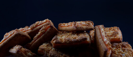 Background of beautiful cookies with orange filling . Square orange cookies .
