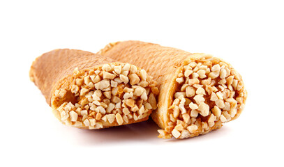 Tube waffles with boiled condensed milk and crushed peanuts are isolated on a white background .