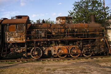 Fototapeta na wymiar Burned-out locomotive is a museum exhibit at the railway station in the city of Trostyanets. Sumy region. Civil buildings. Russian military invasion of Ukraine.