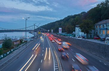 KYIV, UKRAINE, September 04, 2017: Embankment highway with tight traffic, pensot bridge in the background, evening photo
