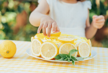 girl eating lemon Birthday cake. Lemonade birthday party at summer park. food, celebration and...