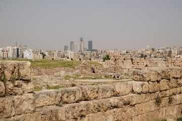 Ruins of Citadel Jebel Al Qala'a in Amman, Jordan. Panorama of Amman city with modern buildings in background.