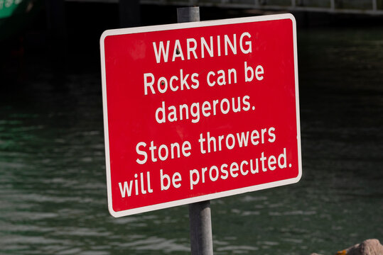 Gosport, Hampshire, UK. 2022. Red warning sign. Rock throwers will be prosecuted sign on the waters edge in Gosport UK