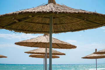 Top of beach umbrellas at sunny day. Straw umbrella in blue sky