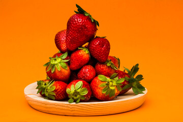 Fresh strawberries on orange background