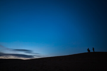Fototapeta premium silhouette of people walking in the desert