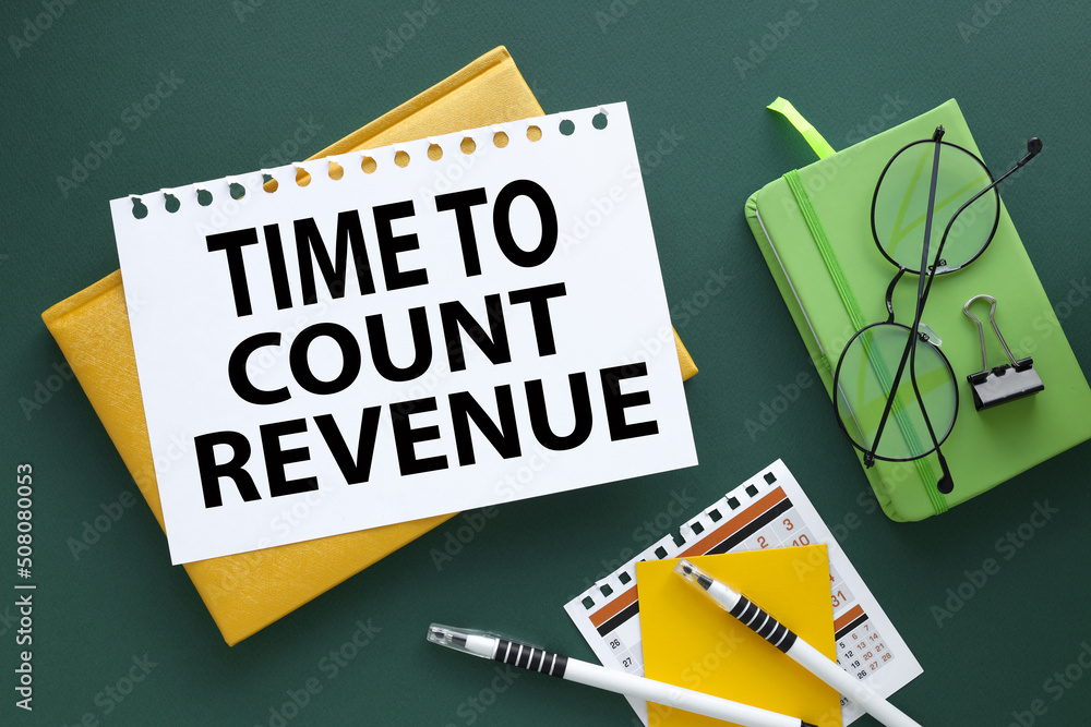 Poster time to count revenue . green emerald background text on a page on a yellow notepad. glasses on gree