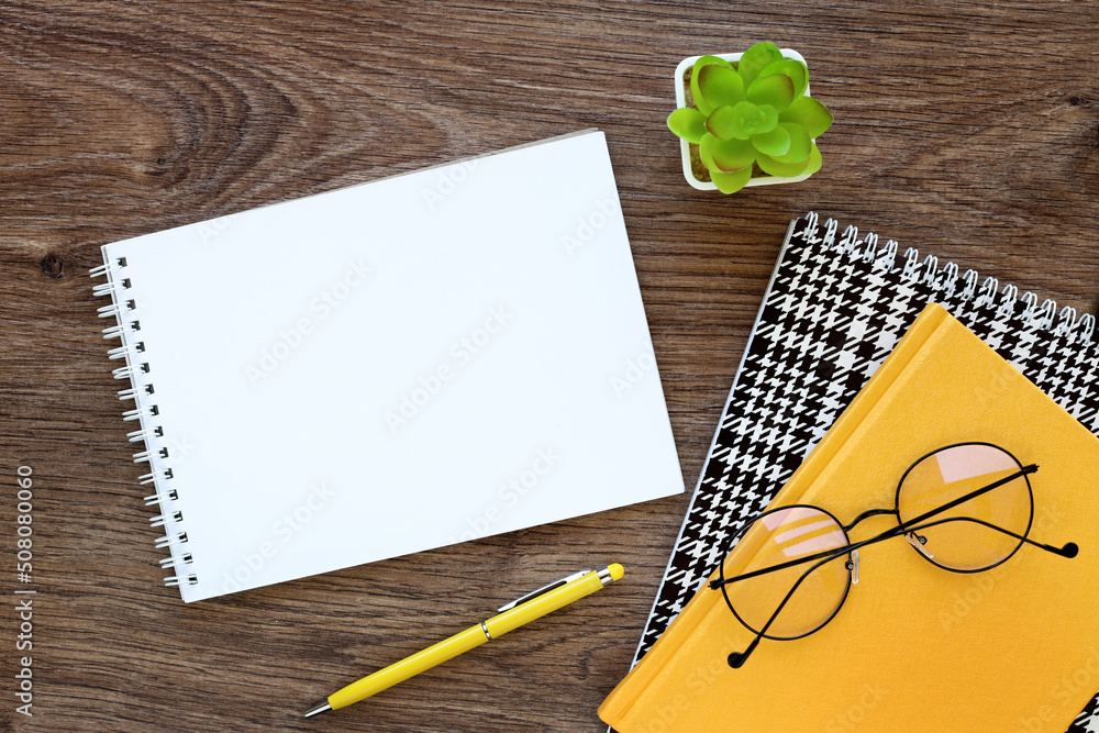 Poster top view image of an open notebook with blank pages next to a yellow notebook with a potted plant an