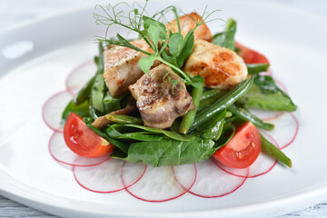 grilled meat and fish with green salad and tomatoes