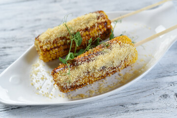 grilled corn on the cob with parmesan cheese and sprouts