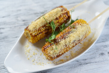 grilled corn on the cob with parmesan cheese and sprouts